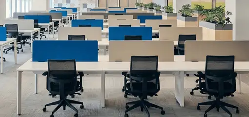 Modern open-plan office space featuring clean workstations, ergonomic chairs, and sanitized carpets provided by professional office cleaning services in Hollywood, FL.